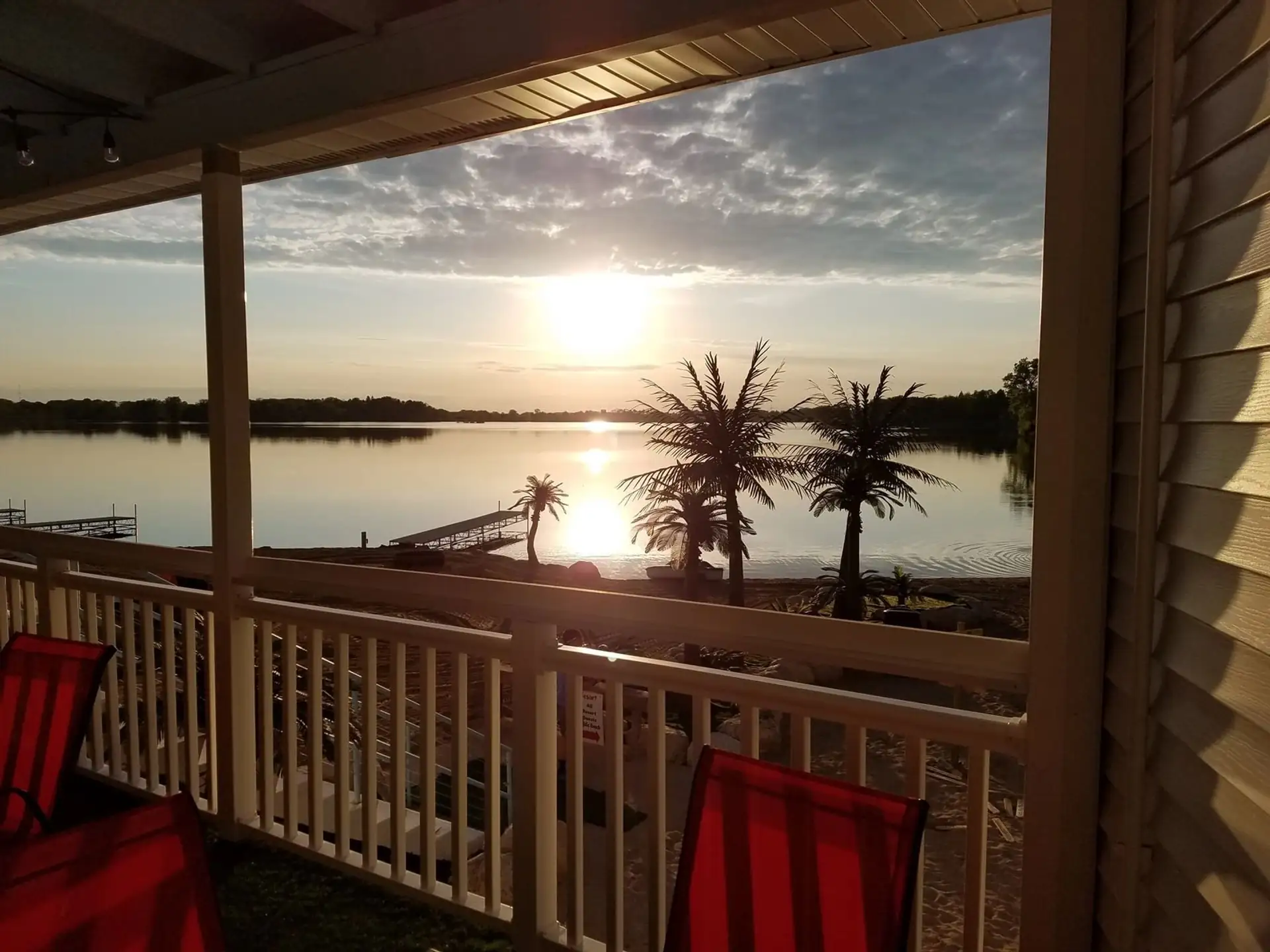 Sunset over the lake and palms from the balcony rail