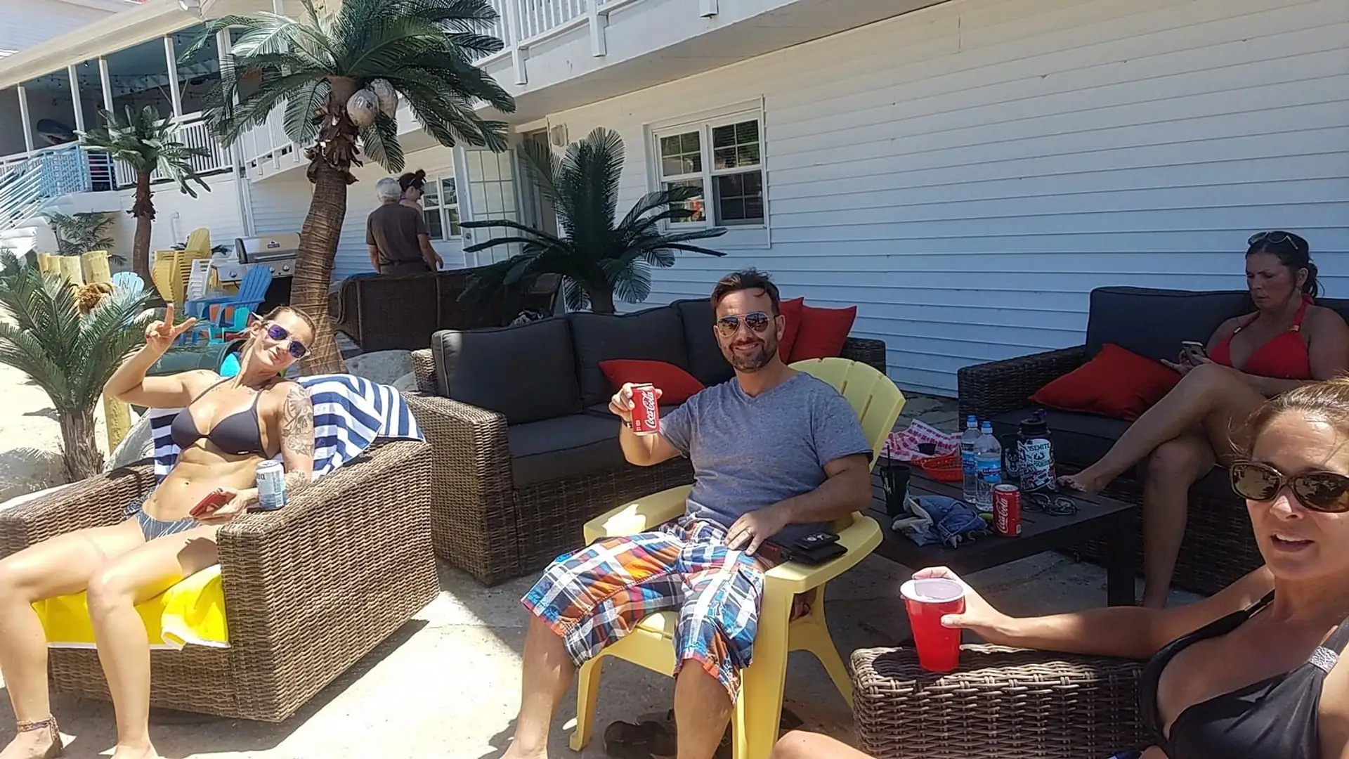 Guests lounging on patio couches by the beach