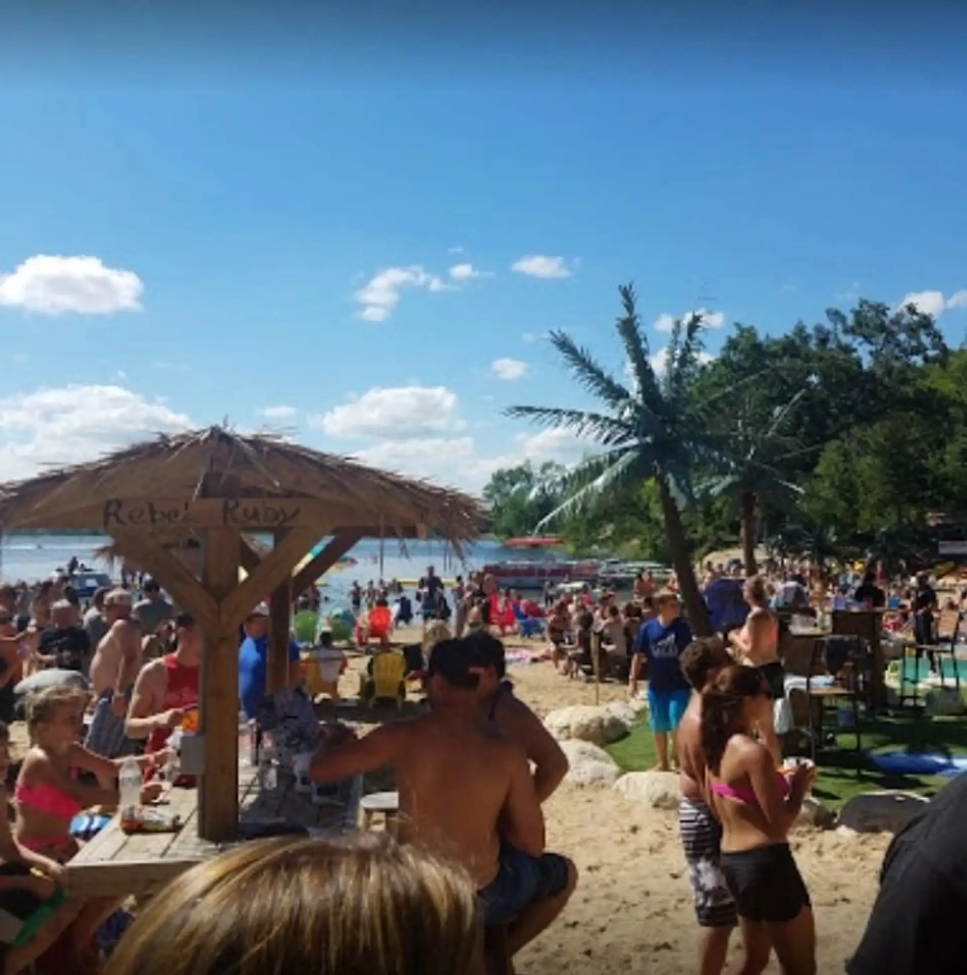 A packed summer beach party around the tiki hut