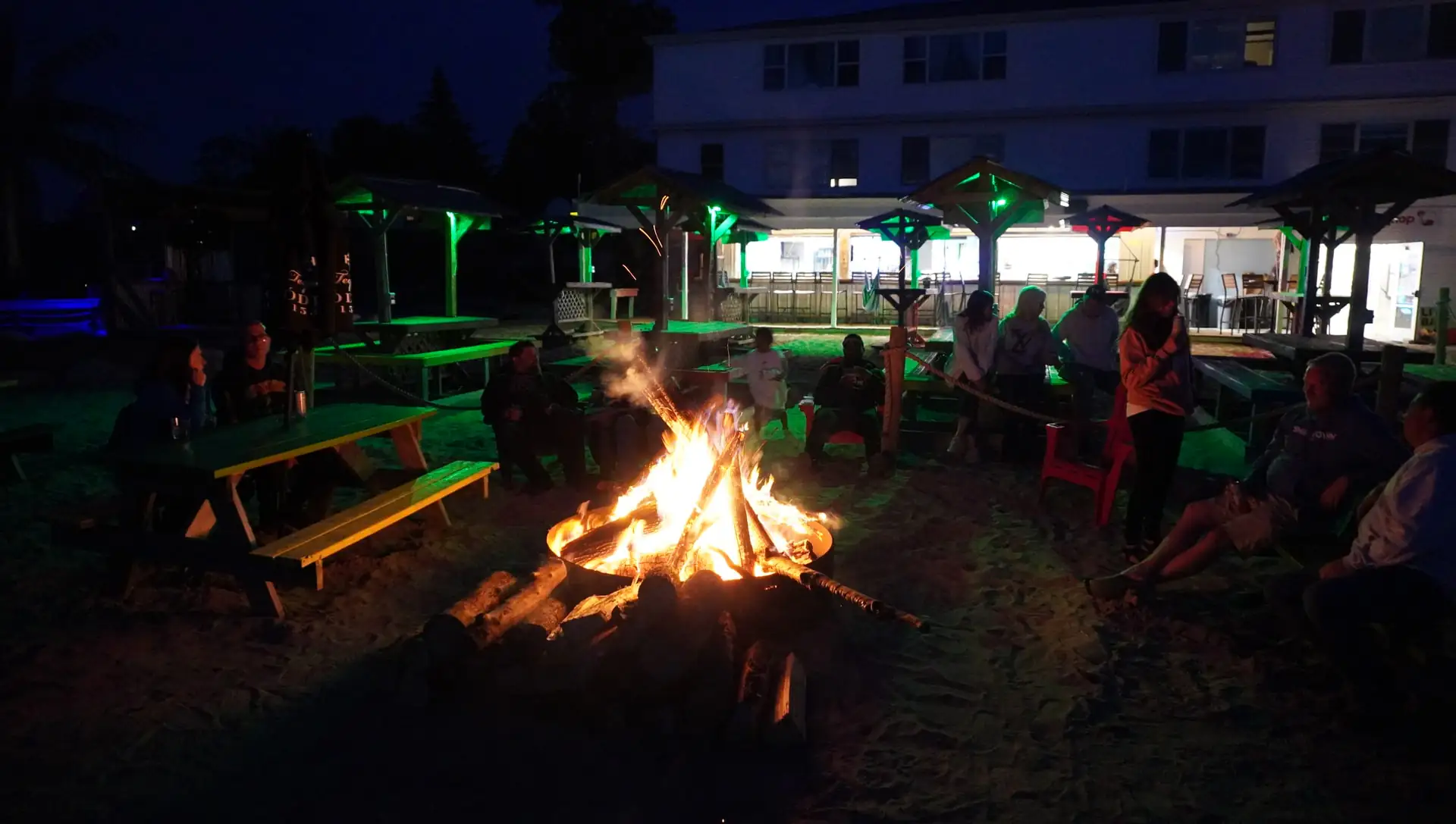 Late-evening bonfire glowing on the beach by the resort