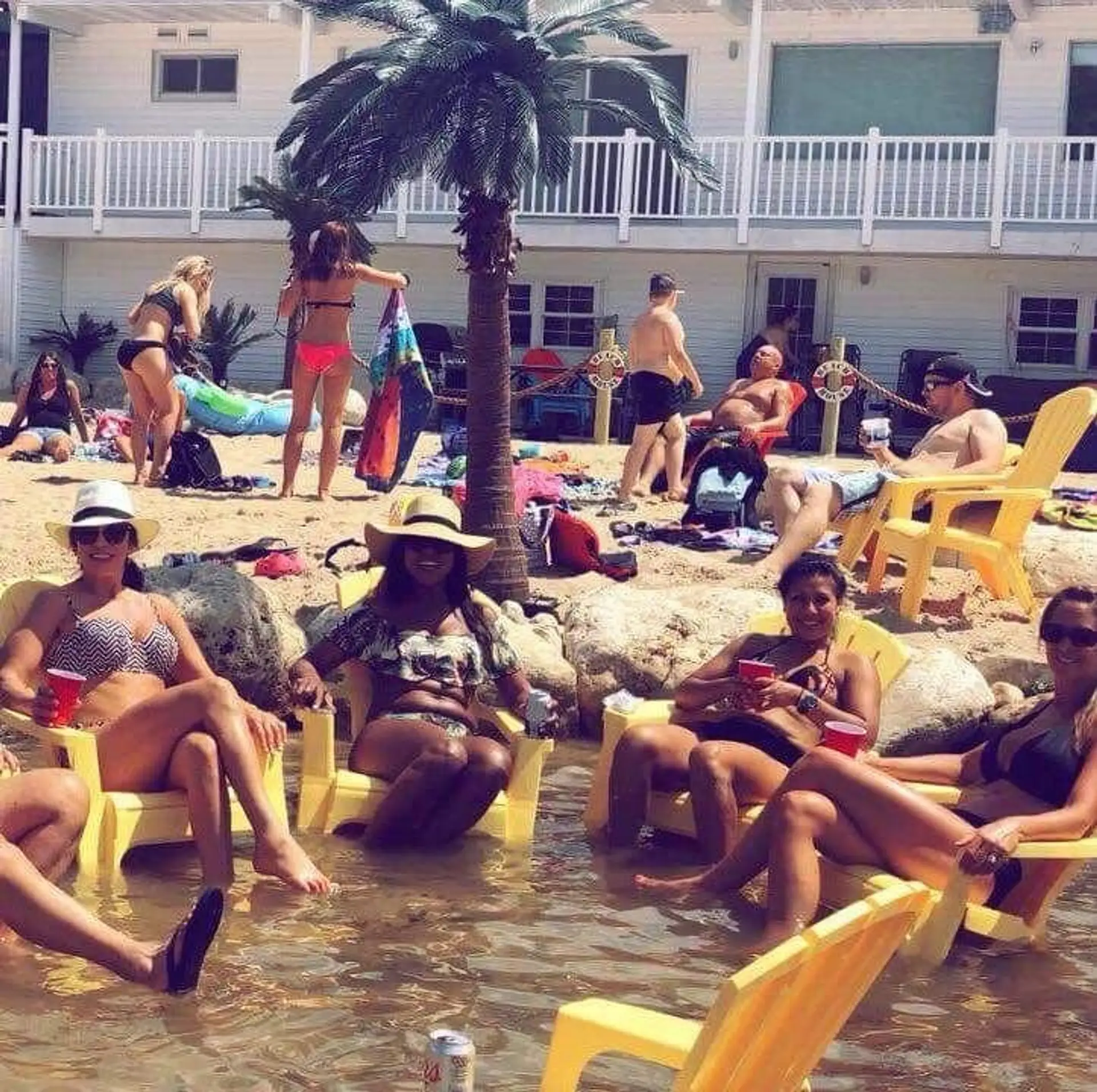 Guests relaxing in Adirondack chairs in the shallow water