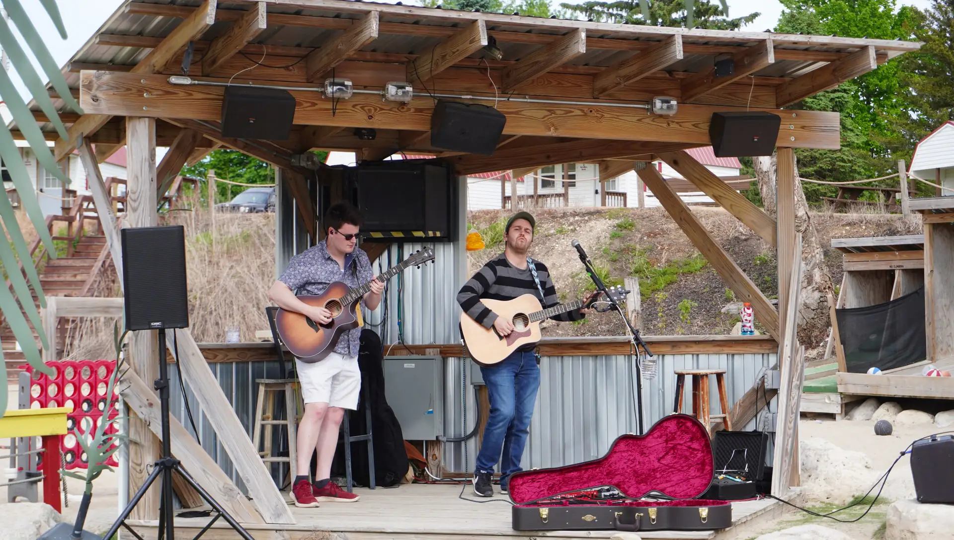 An acoustic duo playing the thatched beach stage