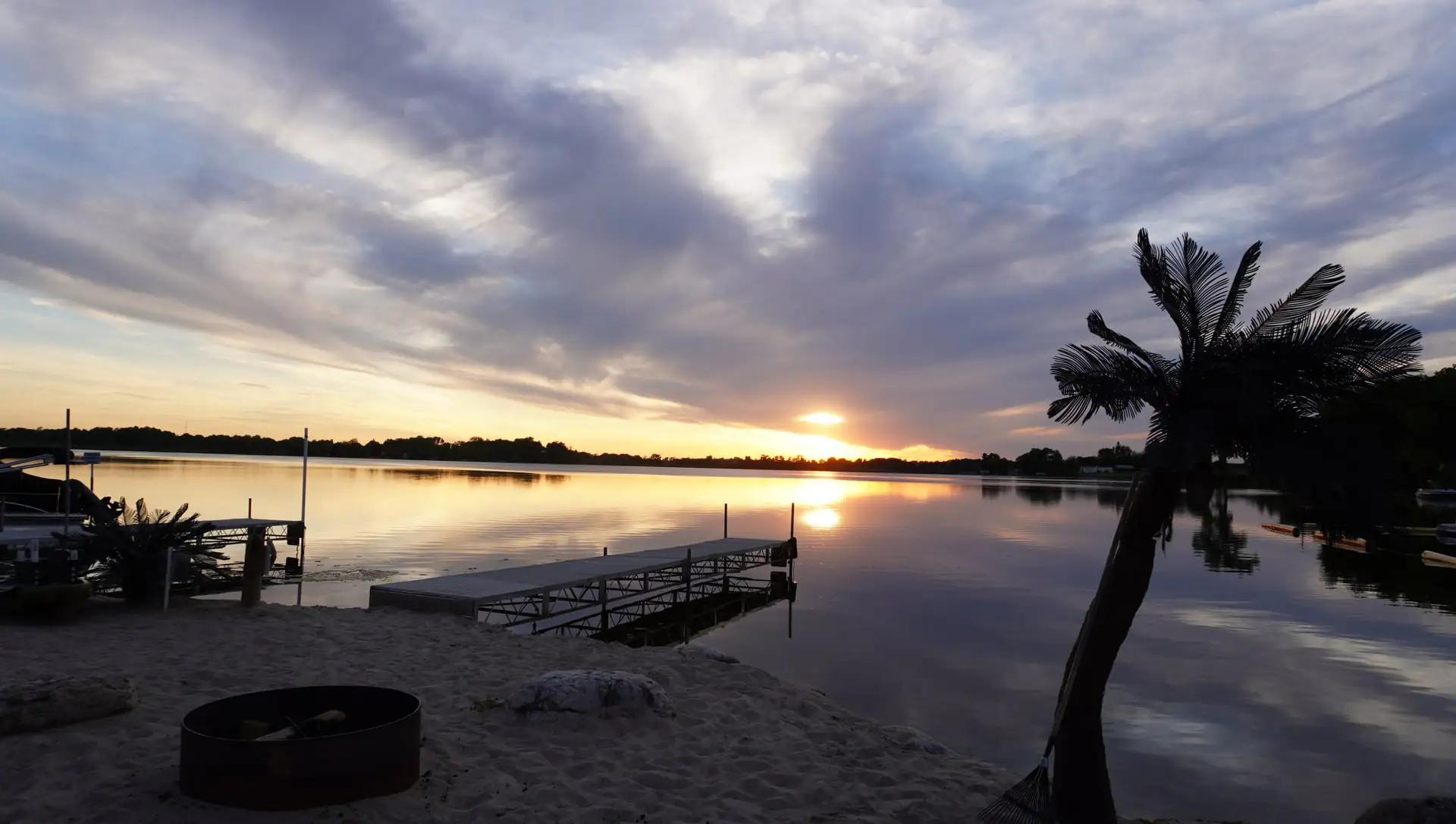 Golden-hour sunset over Kettle Moraine Lake with the palm and dock